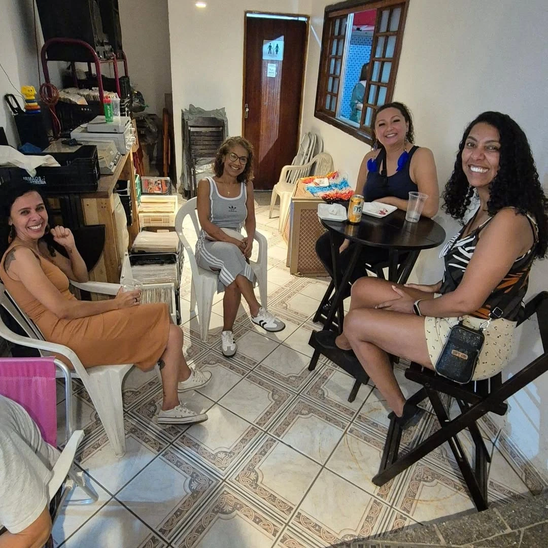Visitantes nas mesas do espaço interno do Quintal da Carolina.