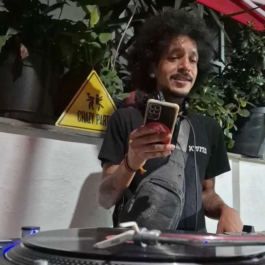DJ selecionando música em vinil na bancada do Quintal.