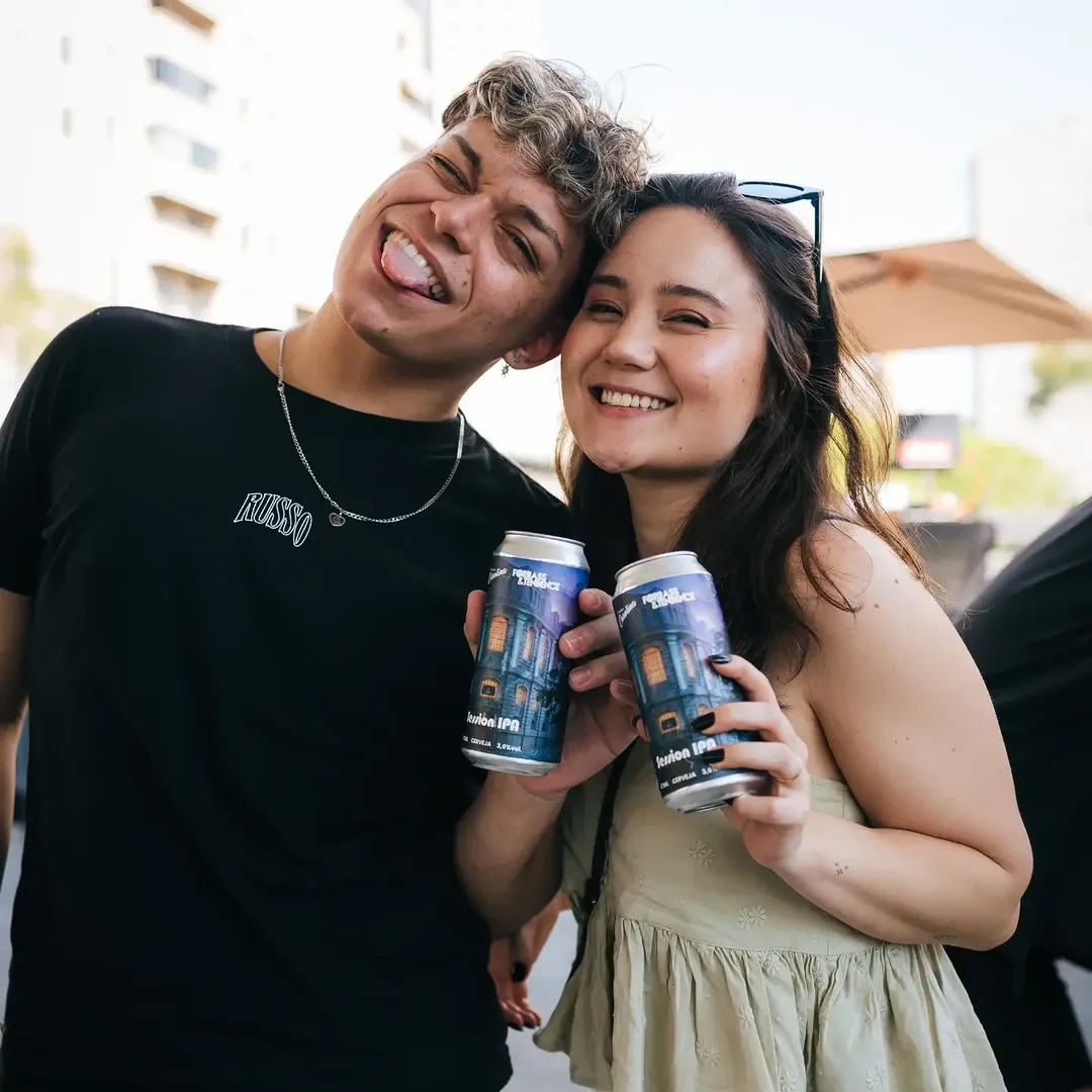 Casal apresentando latas da colaboração Carolina e Forbass & Tendence.